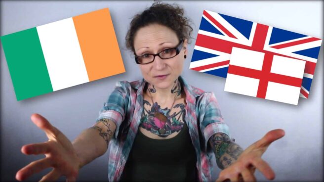Emily Moran Barwick of Bite Size Vegan is shown from the waist up, arms outstretched toward the camera, palms open, fingers splayed. Over her right shoulder is the tricolour; the flag of Ireland. To her left is the Union Flag of Great Britain. In front of that and slightly lower down is a smaller flag. This one is the cross of St. George; the flag of England.