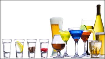 A range of different and colorful alcoholic beverages are displayed in a line.