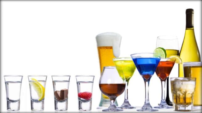 A range of different and colorful alcoholic beverages are displayed in a line.