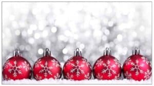 A row of red and silver festive baubles are shown across the bottom with a white, glittery background behind.