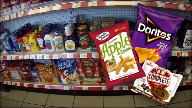 The image is of shelves of pre-packaged food, the sort you would expect to find in a grocery store or gas station. Overlaying the image is an image of some of the various vegan options typically available.