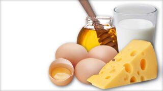 The image shows a number of hen’s eggs, a chunk of cheese, a glass of honey and a jar of honey.
