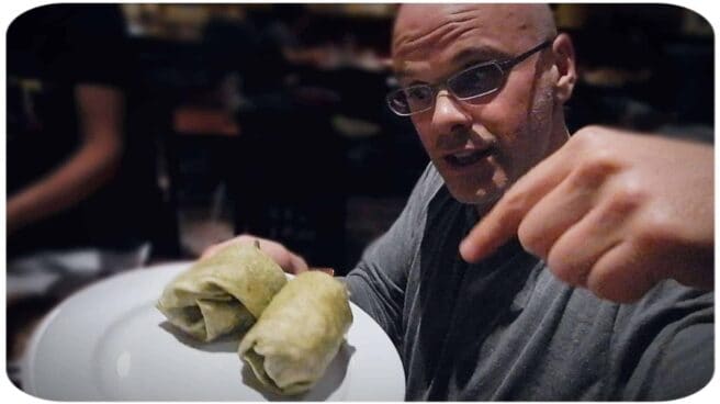 Author and vegan activist Gary Yourofsky is shown pointing at a plate of delicious vegan food.
