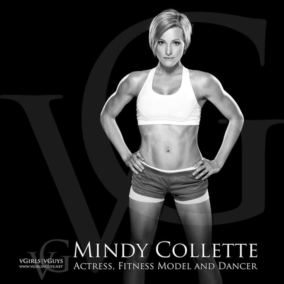 Mindy Collette actress, fitness model and dancer in workout attire standing with hands on hips, on a black background with her name in white lettering