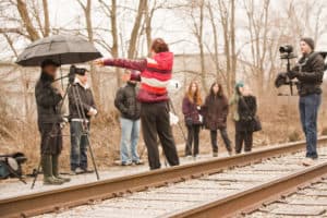 As a number of people watch on from the side of the track, along with a photographer and videographer, Emily can be seen specifying how she wants the demonstration to act out.