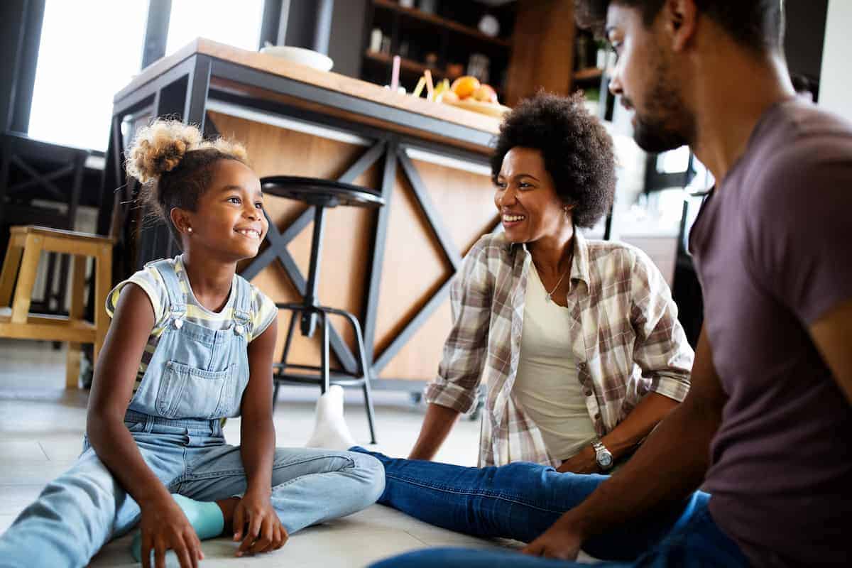 A Black mother and father educating their daughter about veganism in a positive and age-appropriate manner.